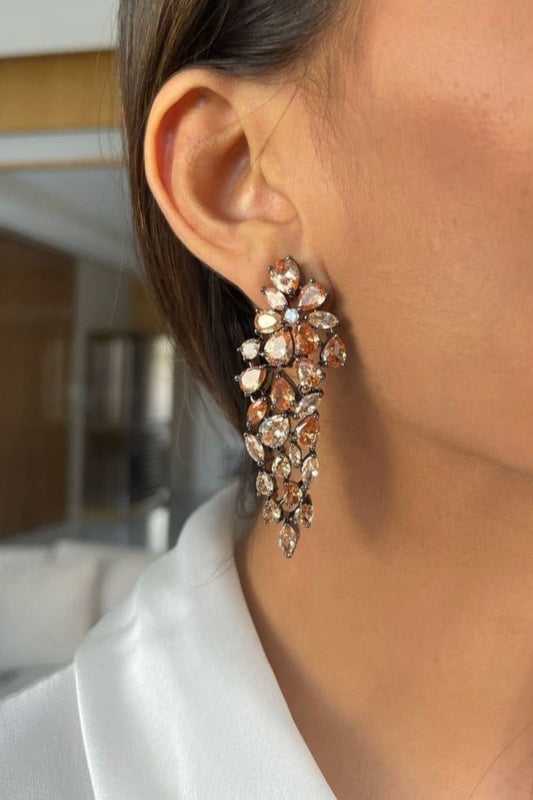Close-up of a person wearing a sparkling earring with a blurred indoor background