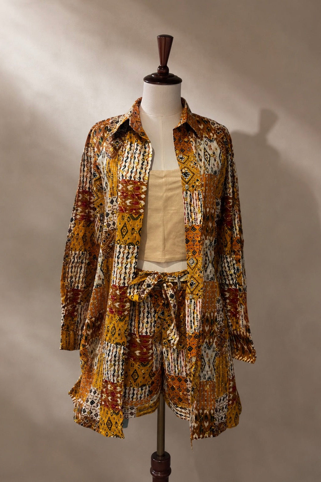 Mannequin wearing a patterned outfit with a shirt and shorts on a plain background