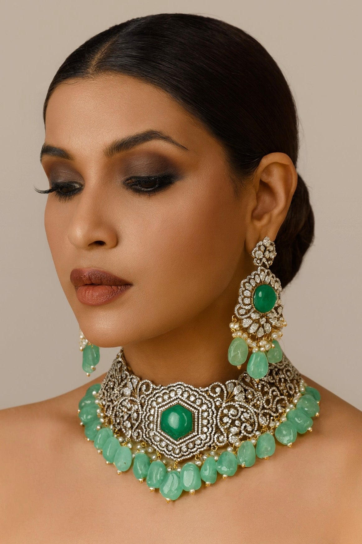 Woman wearing a green and silver jewelry set with a neutral background