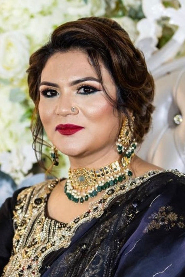Woman in traditional attire with jewelry against a floral background