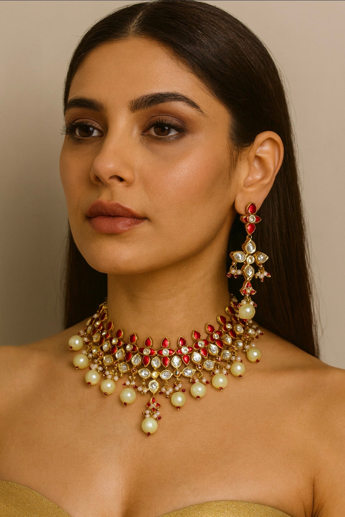 Woman wearing a detailed necklace and earrings against a neutral background